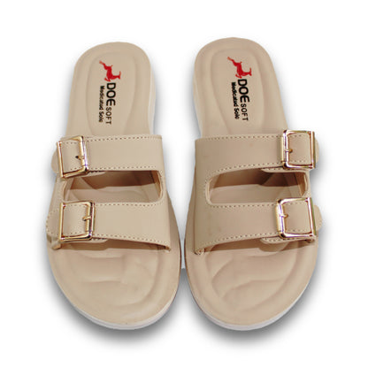 A pair of beige double-strap slide sandals with metallic rose gold buckle details, shown from a top-down view on a white background. The brand name 'DOE SOFT' is printed on the insole.